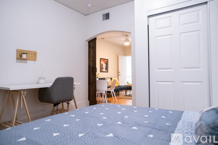 A bedroom with a bed, desk, and chair.
