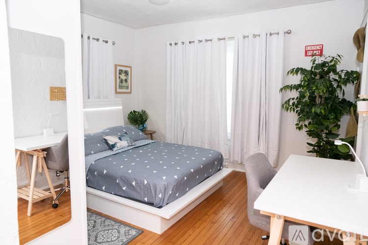 A bedroom with a bed, desk, and chair.