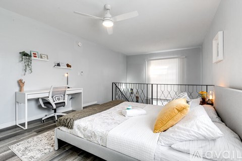 A bedroom with a bed, desk, and chair.