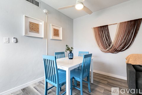 A dining room with a white table and blue chairs.