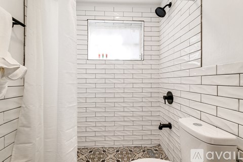 A white bathroom with a toilet and a shower.