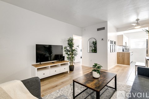 A modern living room with a flat screen TV and a wooden coffee table.