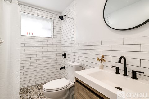 A white toilet in a bathroom with a black faucet.