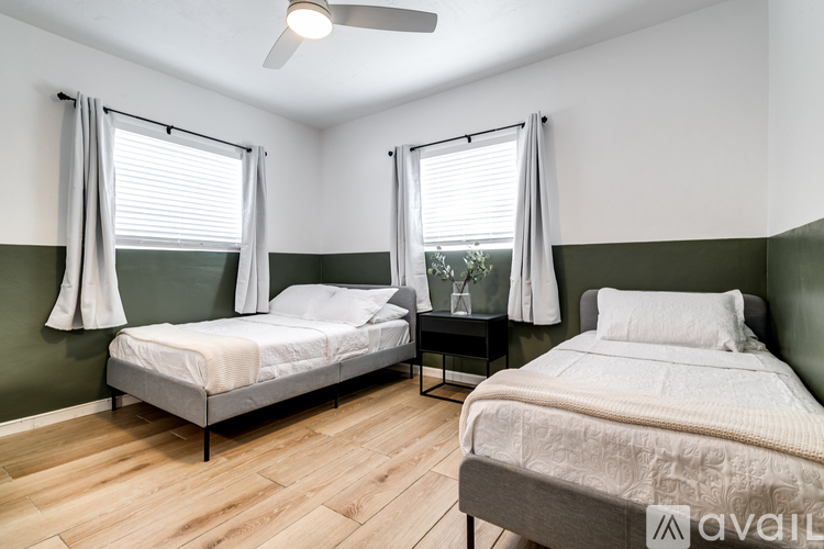 A bedroom with two beds and a ceiling fan.