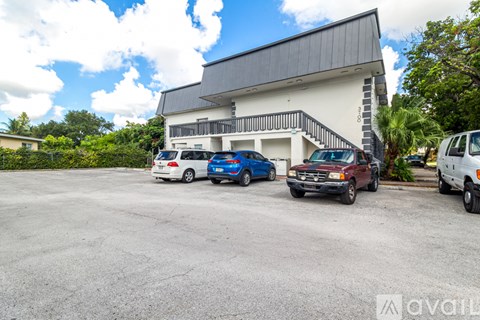 A parking lot with cars and a building in the background.