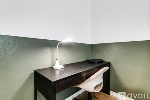 A desk with a lamp and a mouse on it.