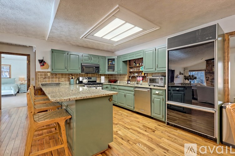 A kitchen with green cabinets and a wooden floor.