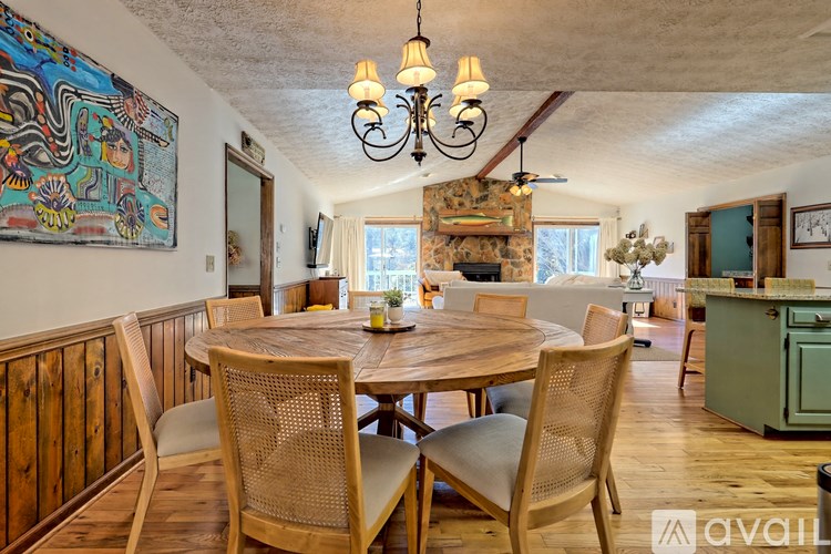 A dining room with a wooden table and chairs.