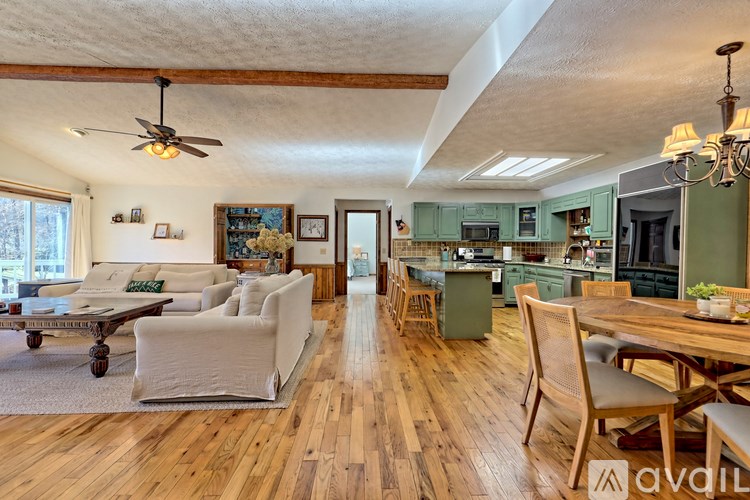 A living room with a couch, chairs, and a dining table.