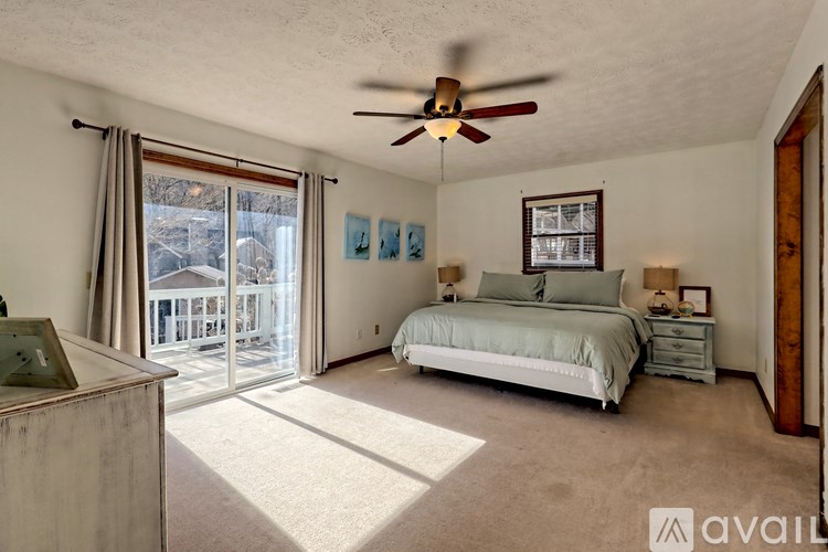 A bedroom with a bed, dresser, and a ceiling fan.