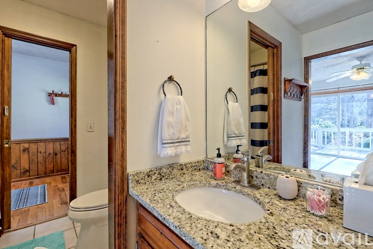 A bathroom with a marble countertop and a large mirror.