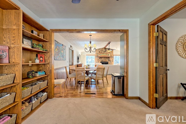 A room with a dining table and chairs is visible through an open door.