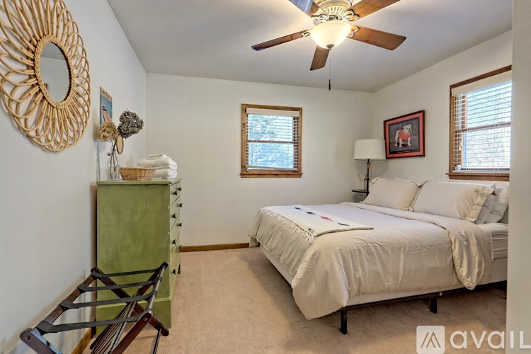 A bedroom with a bed, dresser, and window.