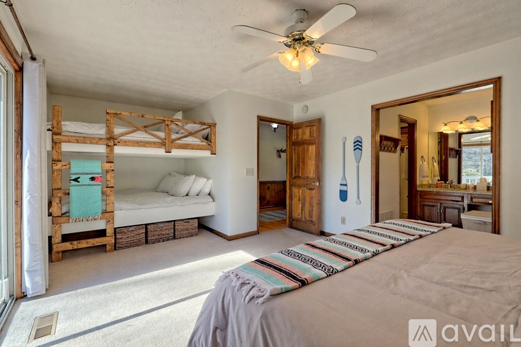 A bedroom with a bed, a bunk bed, and a mirror on the wall.