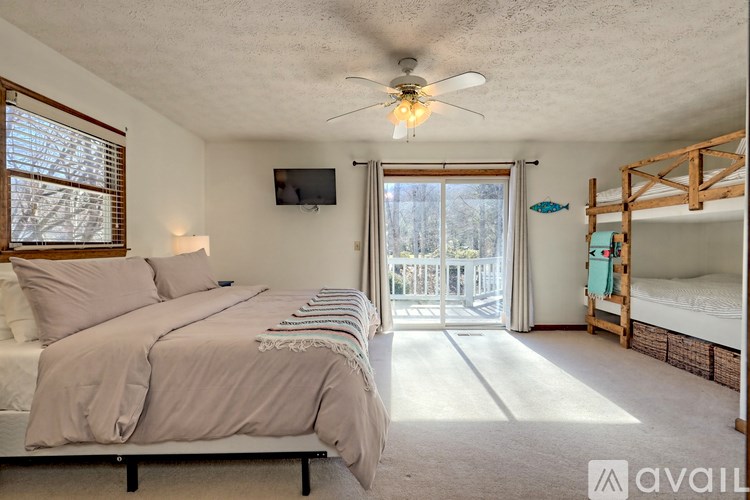 A bedroom with a large bed and a flat screen TV mounted on the wall.
