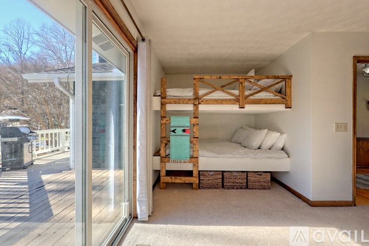 A bedroom with a bunk bed and a sliding glass door.