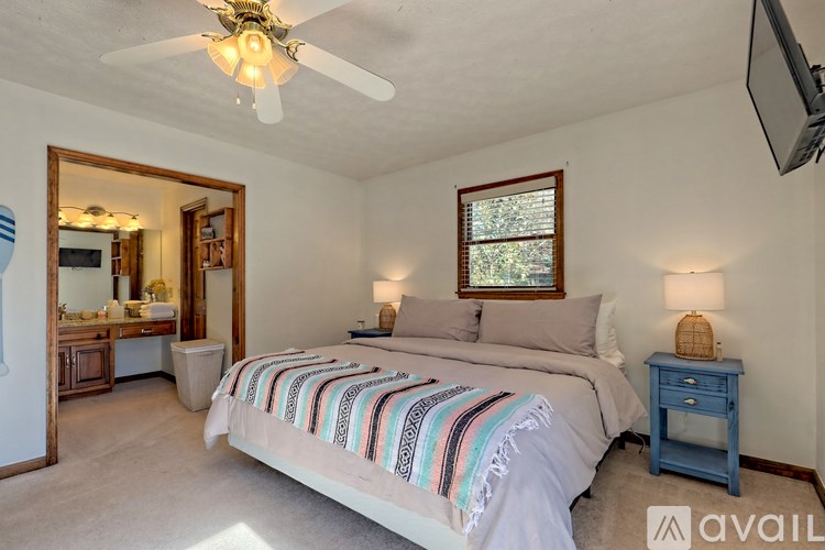 A bedroom with a large bed and a ceiling fan.