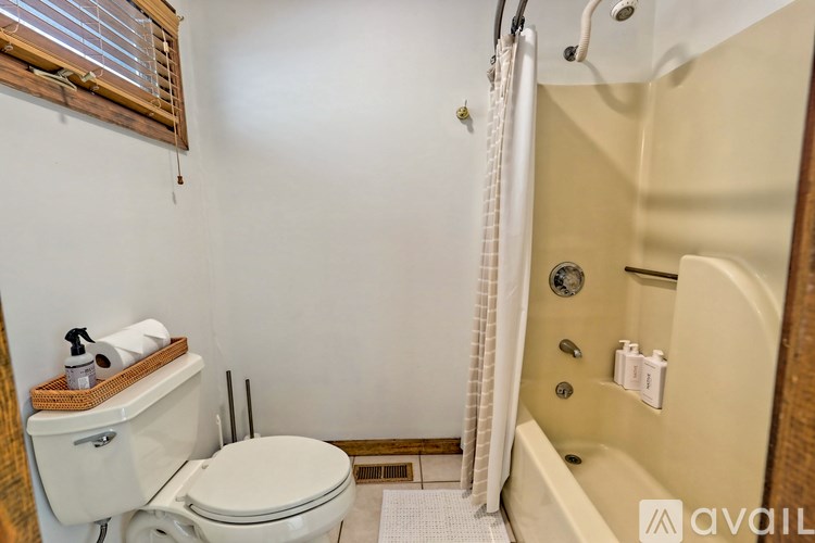 A bathroom with a toilet, a bathtub, and a window.