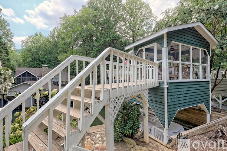 A house with a green roof and a white deck.