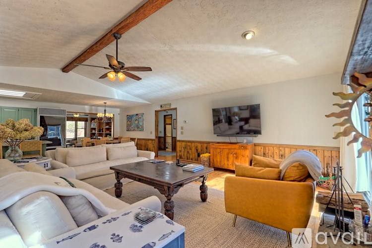 A living room with a yellow couch and a wooden coffee table.