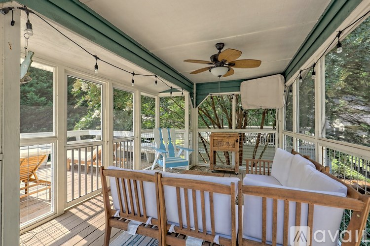 A sunroom with a white couch and a ceiling fan.