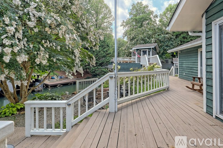 A deck with a white railing and a tree with white flowers.