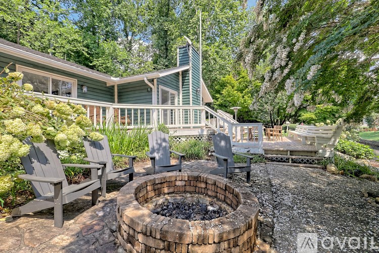 A backyard with a fire pit and chairs.