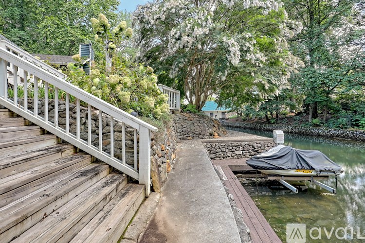 A wooden staircase leads down to a boat docked at the edge of a body of water.