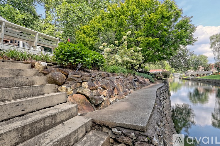 A stone wall runs along a waterway with steps leading up to it.
