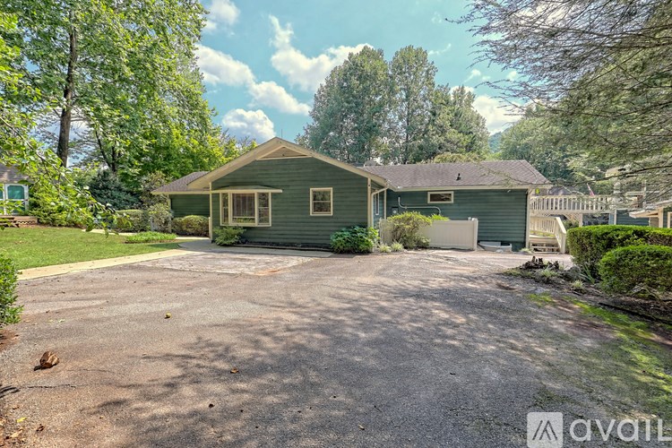 A house with a driveway surrounded by trees.