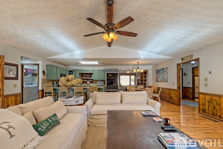 A living room with a white couch and a ceiling fan.