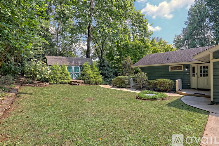 A house with a green lawn and trees in the background.