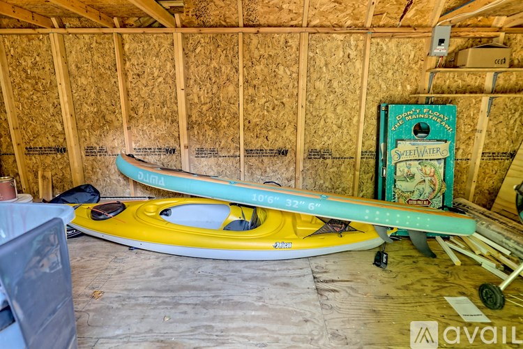 A blue and yellow kayak is on display in a room under construction.