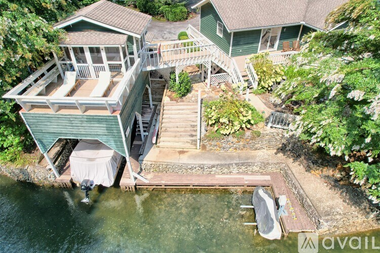A house with a deck and a boat in the water.