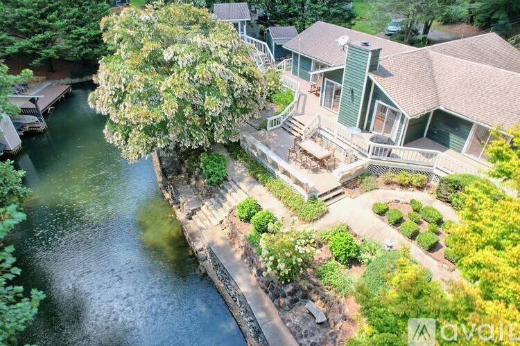 A house with a green lawn and a tree in front of it.