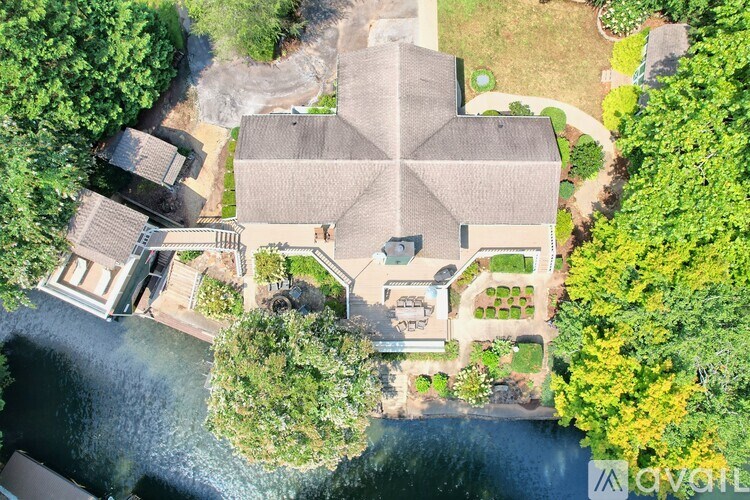 A house with a large front yard and a pond in front of it.