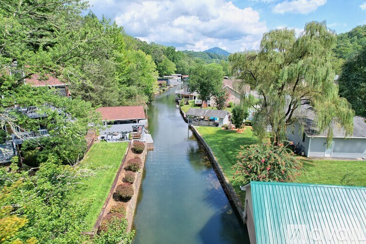 A river flows through a residential area with houses on both sides.