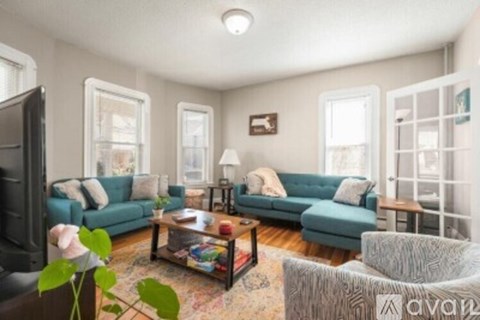 A living room with a blue couch, a coffee table, and a television.