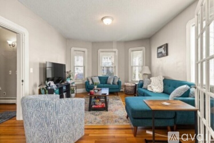 A living room with a grey sofa and a grey ottoman.