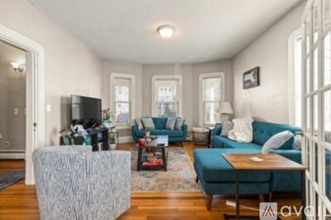 A living room with a grey sofa and a grey ottoman.