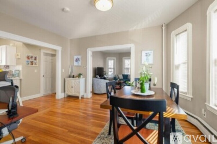 A dining room with a wooden table and chairs.
