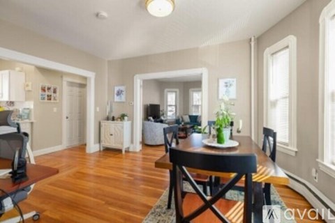 A dining room with a wooden table and chairs.