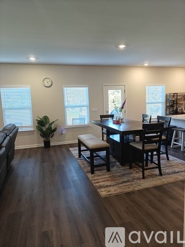 A living room with a couch, a dining table, and a plant.