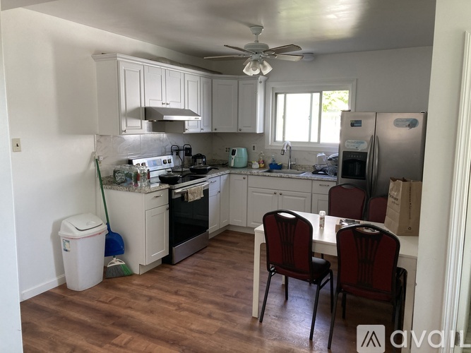 A kitchen with a table and chairs.