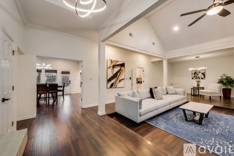 A spacious living room with a white couch and a coffee table.