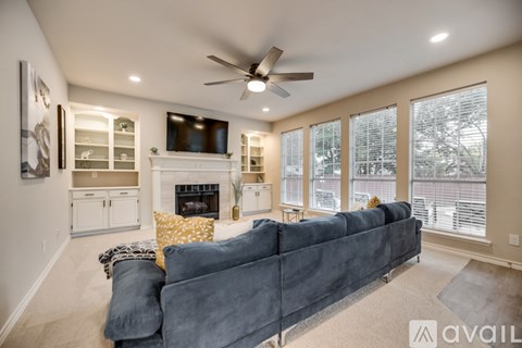 A living room with a grey couch and a fireplace.