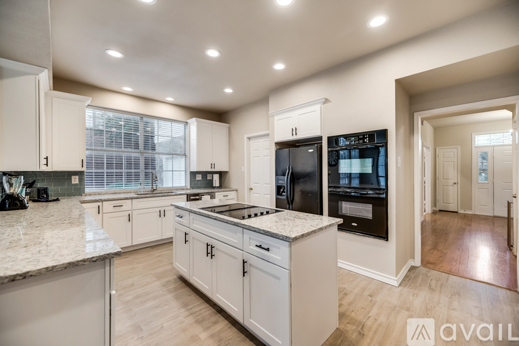 A modern kitchen with white cabinets and a large island.