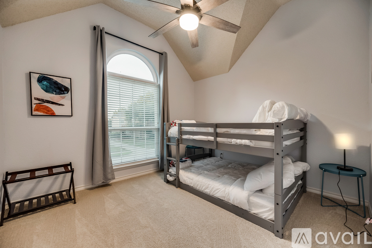 A bedroom with a bunk bed and a ceiling fan.