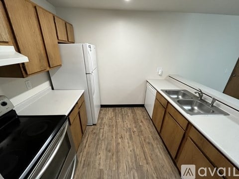A kitchen with wooden cabinets and a white fridge.