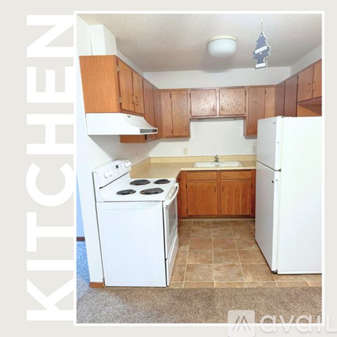 A kitchen with white appliances and wooden cabinets.